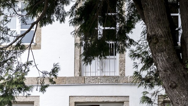 A stone staircase leading to a white door with a decorative iron gate. There are potted plants on either side of the door. - Pensión O Xardin de Julia (Santiago de Compostela)