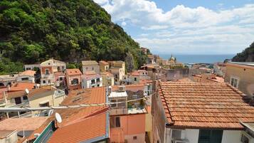 Un pueblo costero con edificios de tejados de terracota, una iglesia destacada y vistas al mar.