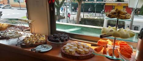 A buffet counter with various desserts and pastries.