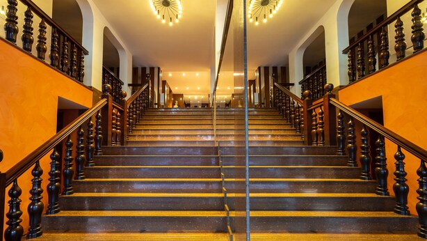 Un magnifique escalier, orné de balustres travaillés et doté d’une main courante, menant à un étage supérieur bien éclairé.