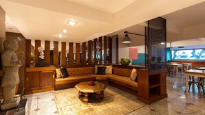 Un salon moderne avec un canapé d’angle, une table basse et une statue en pierre.