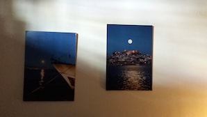 Dos cuadros con escenas costeras, barcos y un paisaje urbano iluminado por la luna.