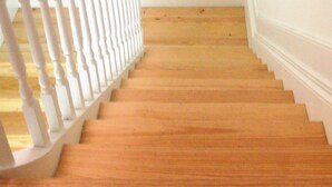 Una escalera de madera con barandillas blancas que lleva a una plataforma.