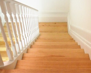 Una escalera de madera con barandillas blancas que lleva a una plataforma.