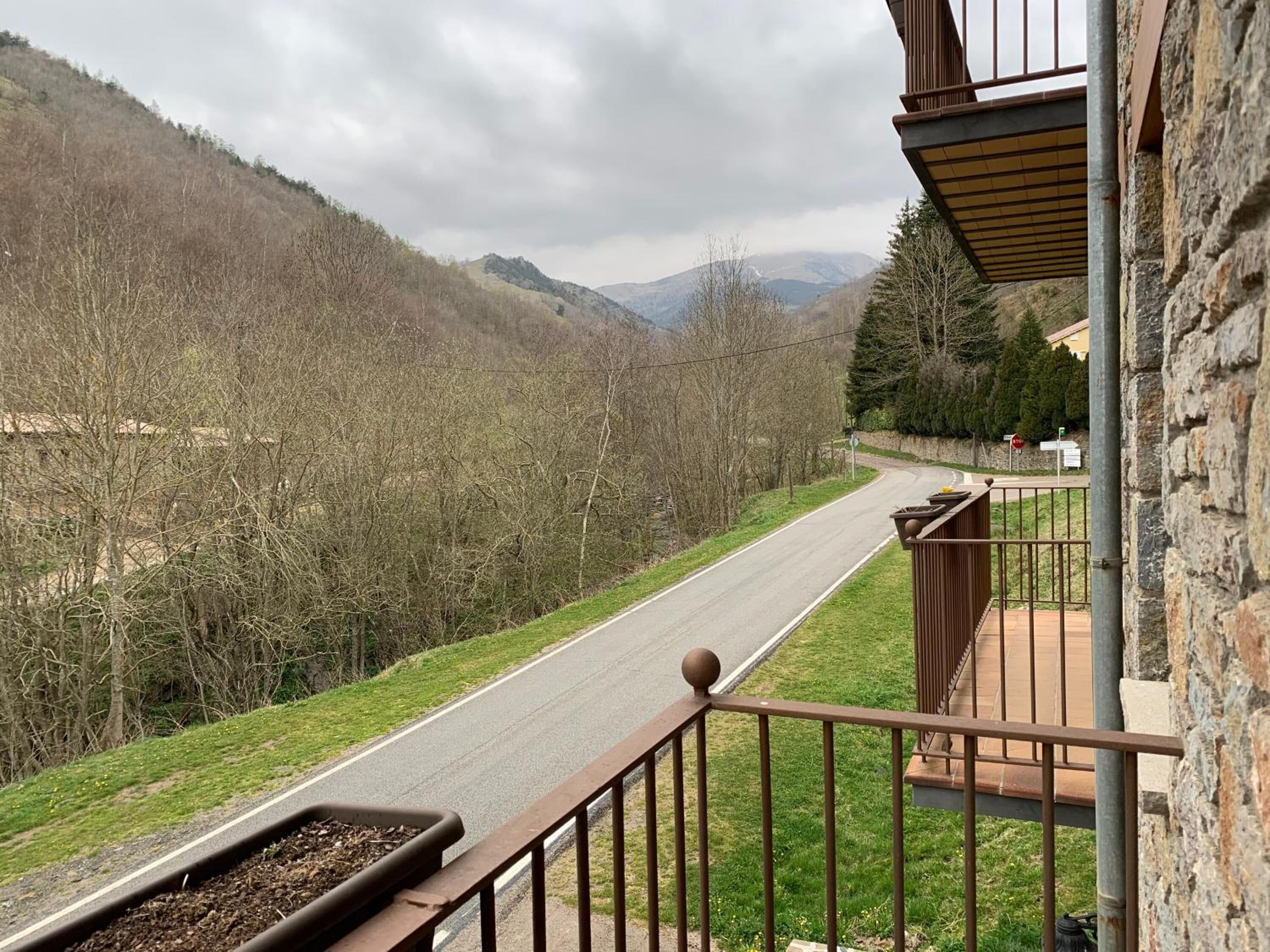 A balcony with a view of a road and mountains.