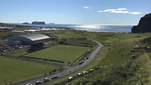 A coastal area with a stadium, roads, and vehicles.