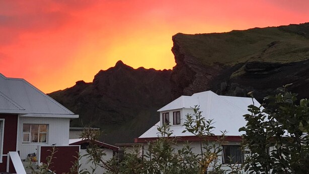 A coastal landscape with a prominent cliff and a sunset.