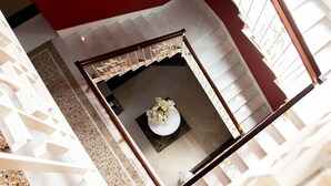 Een modern interieur met een trap, een witte muur en een rode accentmuur.
