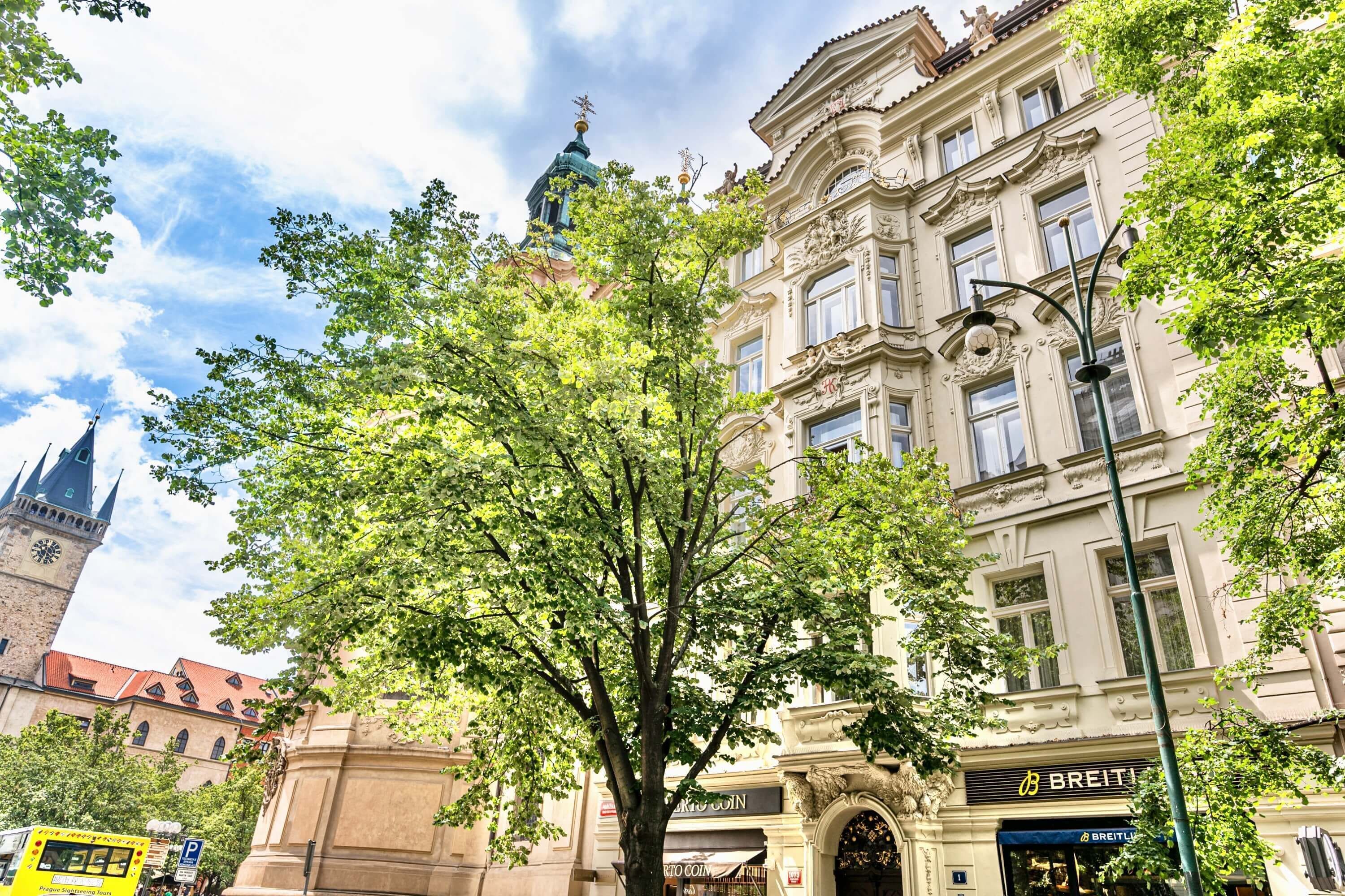 A historic building with ornate architecture, a prominent clock tower, and a BREITLING store.