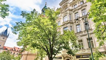 A historic building with ornate architecture, a prominent clock tower, and a BREITLING store.