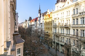 Eine Reihe historischer Gebäude mit aufwendigen Fassaden und einem markanten Kirchturm im Hintergrund.
