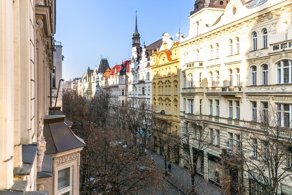 A row of historic buildings with ornate facades and a prominent church steeple in the background.