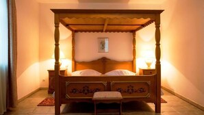 A four-poster bed with a canopy, two bedside tables, and a small bench. - Hotel Kralj Tomislav (Nova Gradiska)