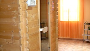 A wooden sauna with a glass door, a tiled floor, and an orange curtain. - Hotel Kralj Tomislav (Nova Gradiska)