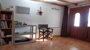 A room with a bookshelf, a desk, a chair, a radiator, and a wooden door.