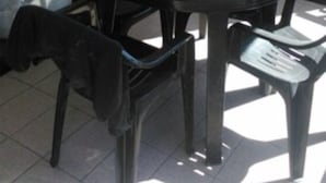 Une table ronde avec quatre chaises, une veste noire posée sur le sol et une fenêtre avec des rideaux.