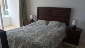 A bedroom with a large bed, two bedside tables, and a window with curtains. - Fragata 802 (Coquimbo)