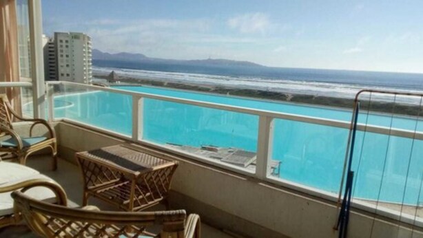 A balcony with a view of the ocean and a swimming pool. - Piscina Cristalina Coral (La Serena)