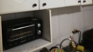 Keittiössä on valkoiset kaapit, musta leivänpaahdin ja pesuallas, jonka hanassa on keltainen nuppi.