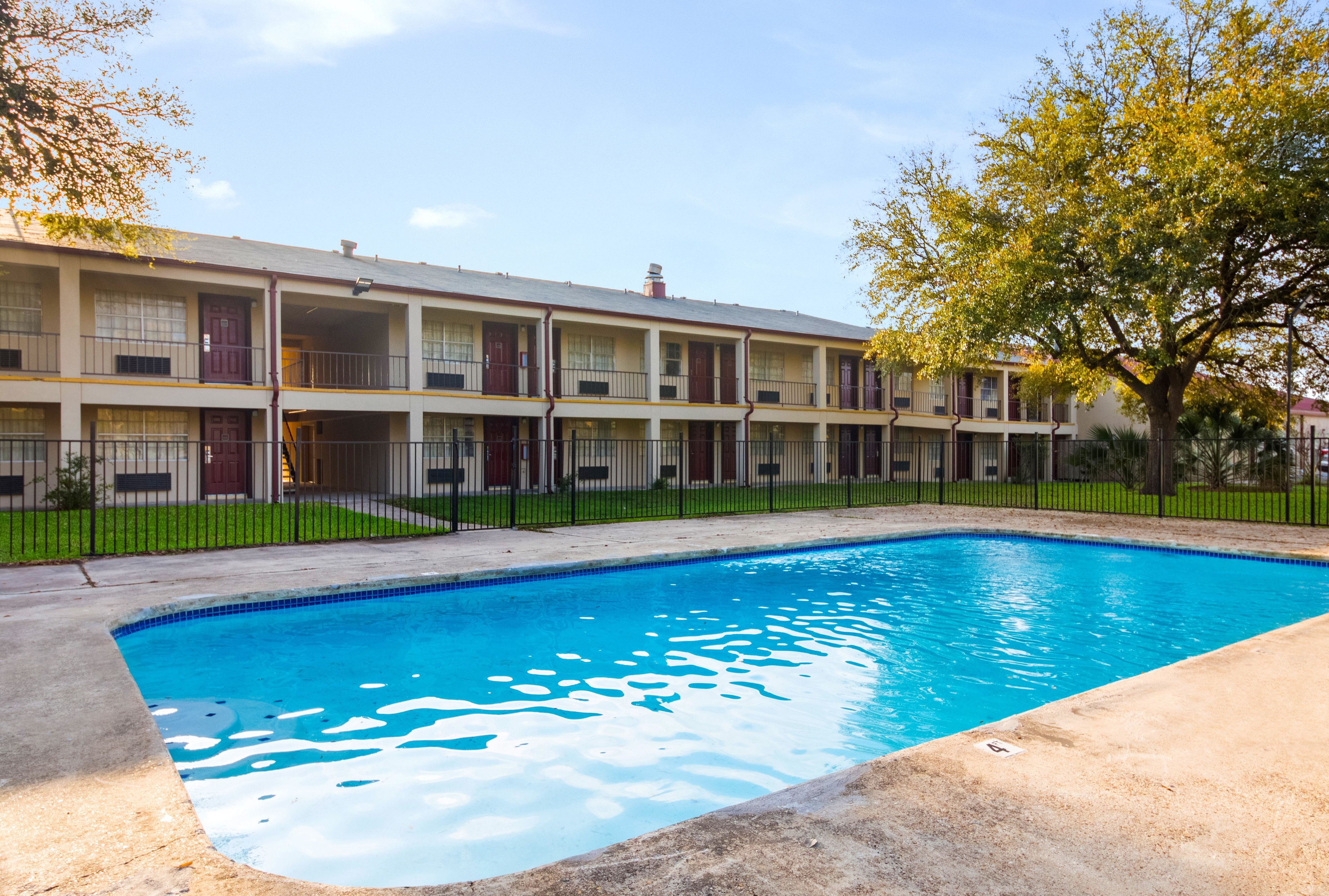 A multi-story motel with a swimming pool.