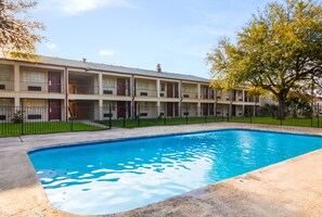 A multi-story motel with a swimming pool.