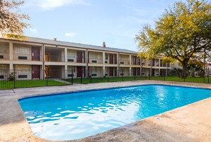 Un motel de varios pisos con piscina.