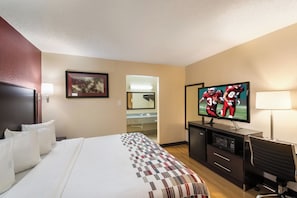 A hotel room with a bed, a desk, a television, and a bathroom visible through an open door. - Red Roof Inn Temple (Temple)