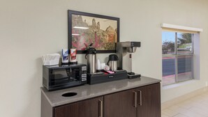 A coffee station with a coffee maker, a microwave, and a coffee creamer dispenser. - Red Roof Inn Temple (Temple)