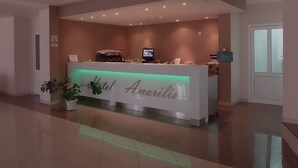 A hotel reception desk with a modern design, a digital screen, and a sign reading "Hotel Amarilis". - Hotel Amarilis (Netretic)
