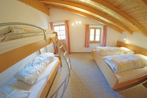 A dormitory room with bunk beds, a ladder, and two windows with curtains. - Unterbergerhof (Val di Vizze)