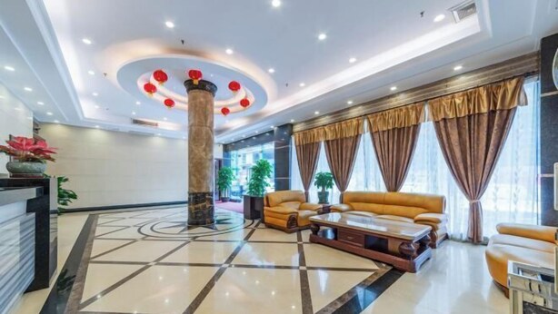 A modern lobby with a marble floor, leather sofas, a reception desk, and large windows with curtains. - Kaiping Fujing Hotel (Kaiping)