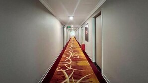 A long, narrow hotel corridor with a patterned carpet and a red border. - Kaiping Fujing Hotel (Kaiping)