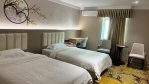 A hotel room with two beds, a desk, a chair, and a decorative wall piece. - Kaiping Fujing Hotel (Kaiping)