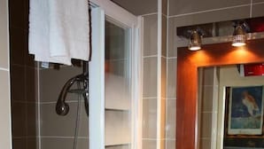 A bathroom with a shower, a sink, and a mirror.