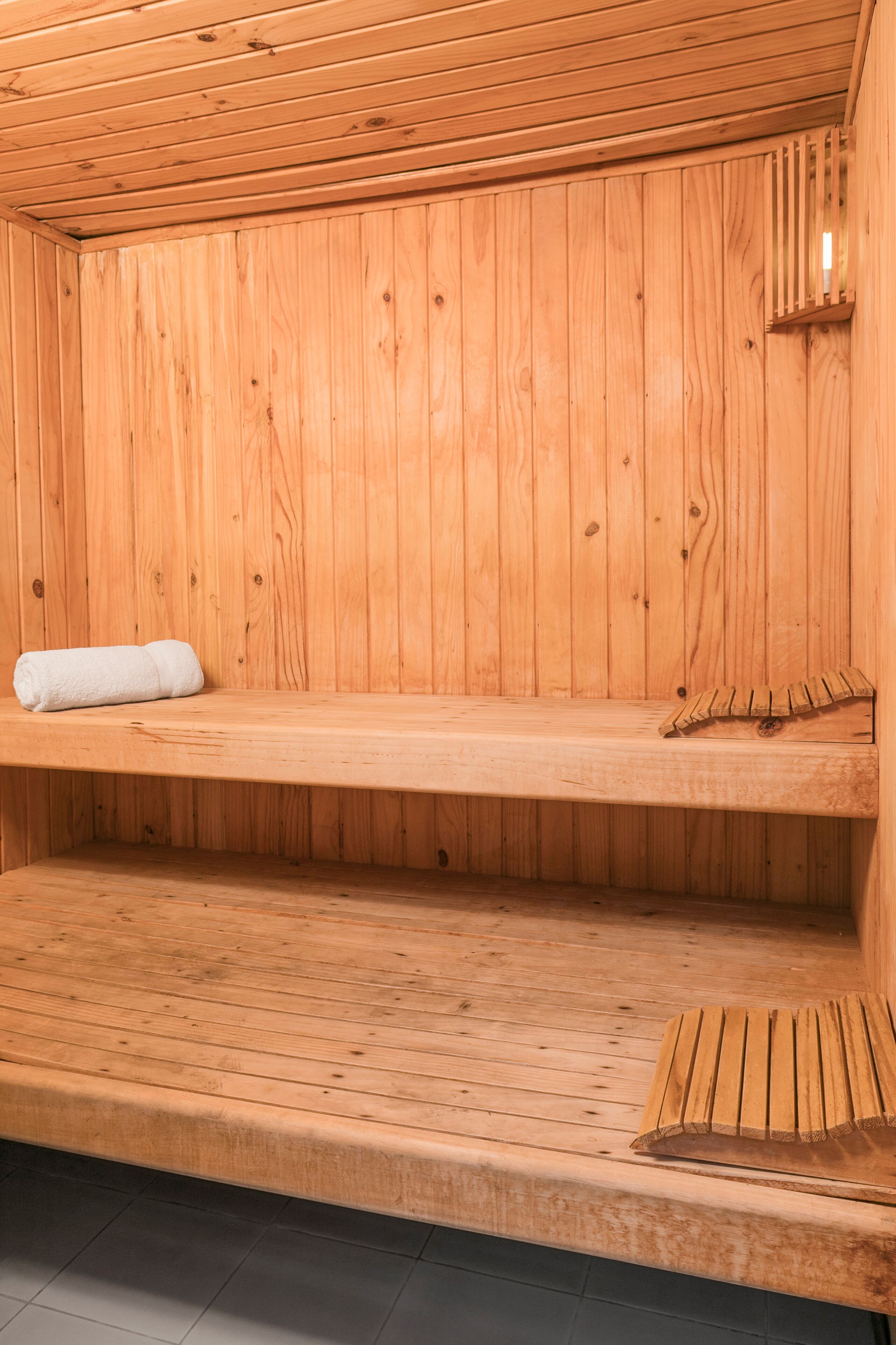 A wooden sauna with a bench and a towel.
