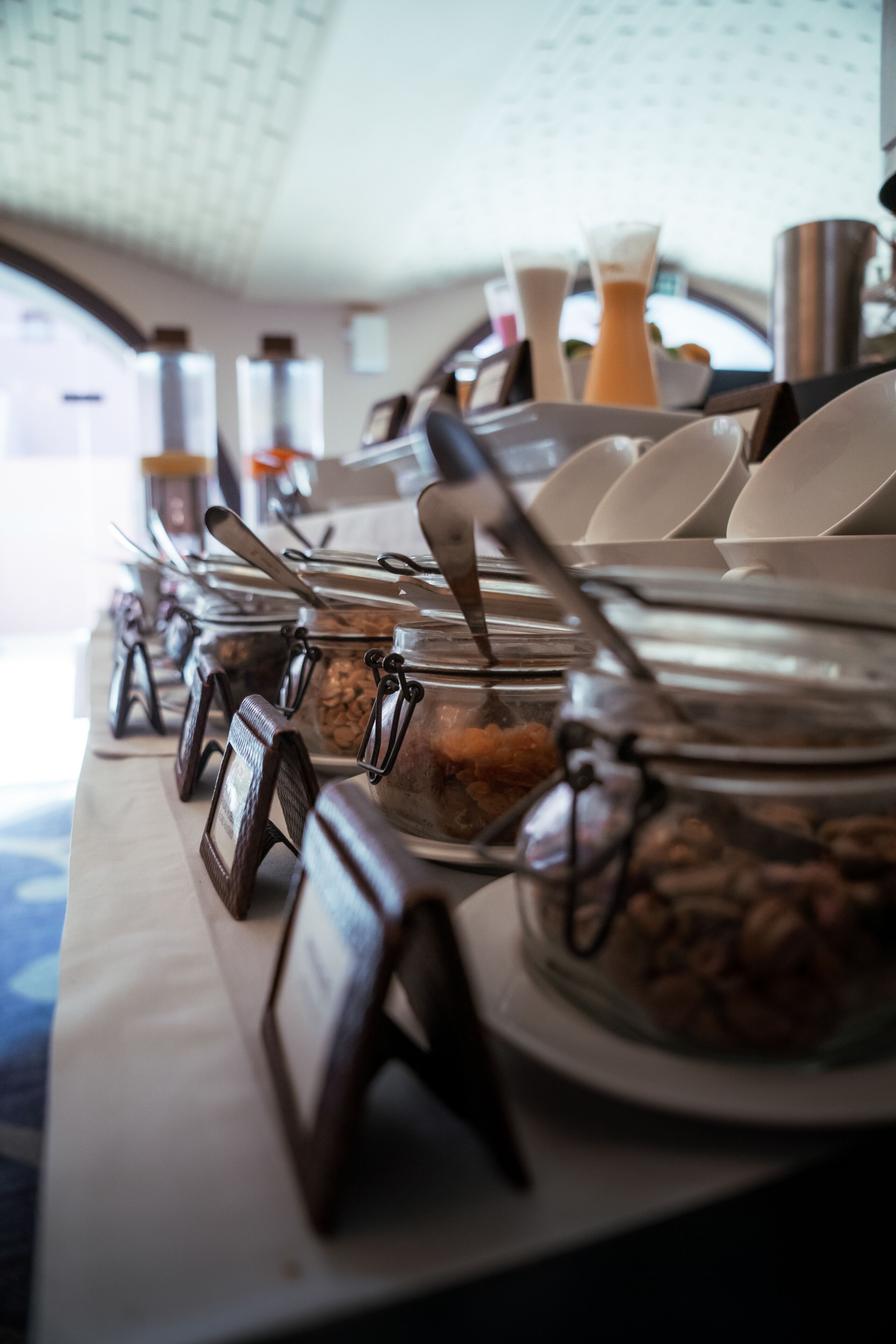 A buffet setup with various food containers and serving utensils.