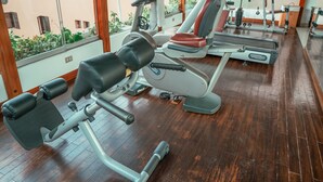 A gym with exercise equipment, large windows, and wooden beams. - Costa del Sol Trujillo Centro (Trujillo)