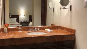 A bathroom with a marble sink, two mirrors, and a vanity.