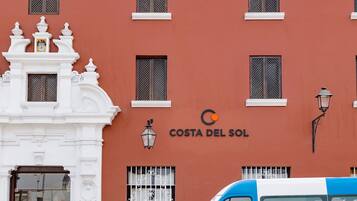 Ein Gebäude mit der Aufschrift "Costa del Sol" und ein blau-weißes Lieferfahrzeug davor.