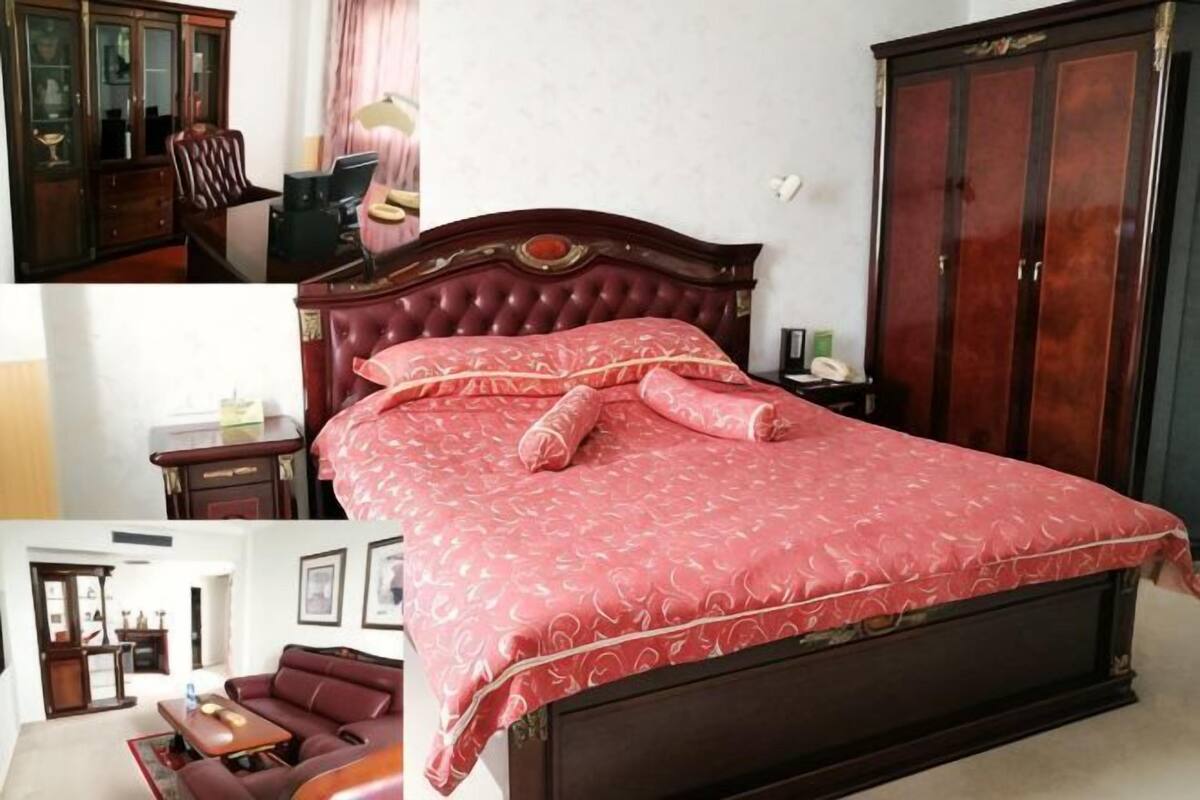 Een slaapkamer met een groot bed, een kledingkast, een bureau en een stoel.