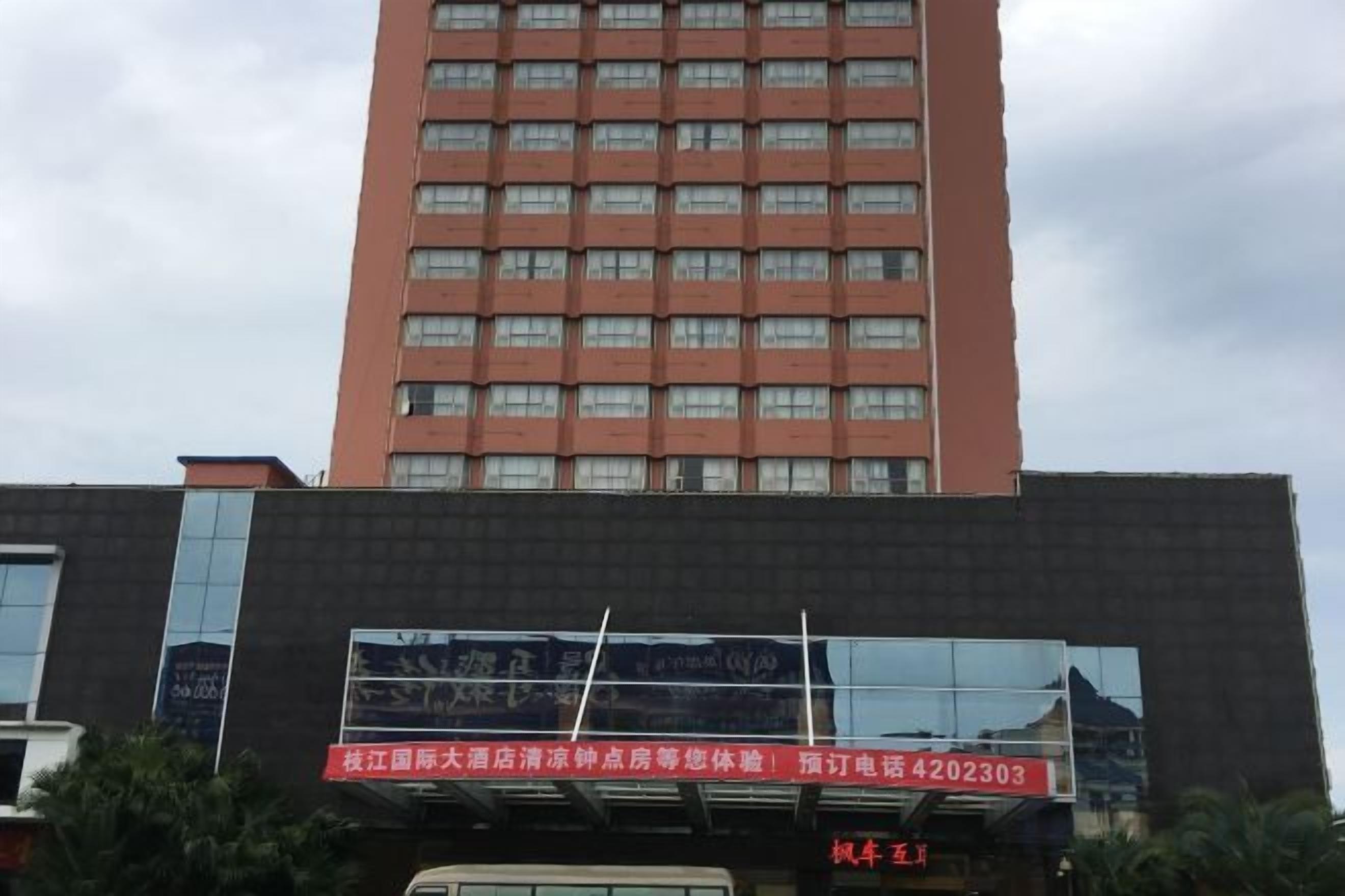 A tall building with multiple windows and a large signboard.