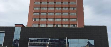 A tall building with multiple windows and a large signboard.