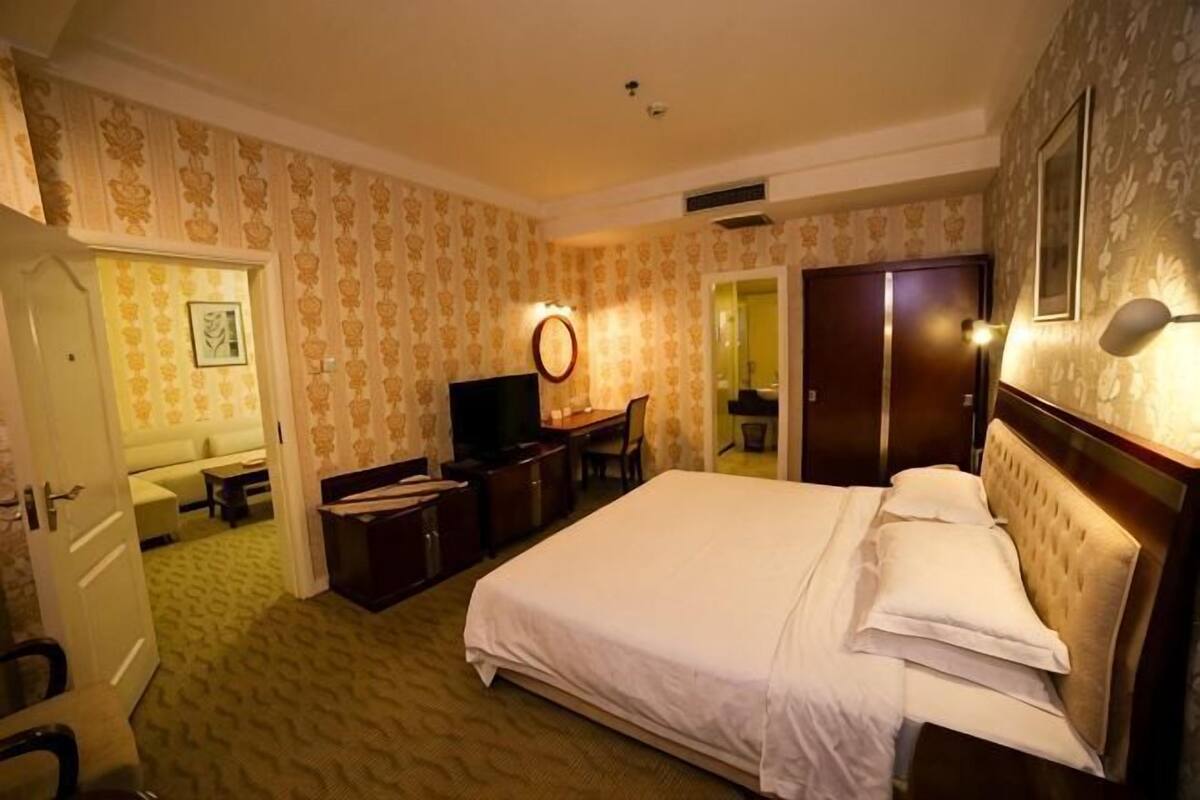 Een hotelkamer met een bed, een bureau, een televisietoestel en een badkamer.