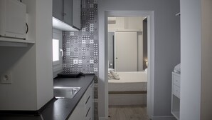 A compact kitchen with a patterned backsplash, a small countertop, and a sink. - Butik Almería Centro (Almeria)