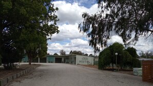 Un camino de grava que conduce a un edificio con el letrero "Sky Motel".