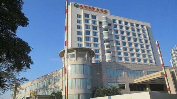 A multi-story hotel building with a modern architectural design, featuring a prominent entrance and a large glass facade. - East Lake International Hotel (Yangjiang)