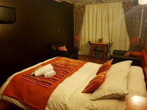 Desk, iron/ironing board, bed sheets