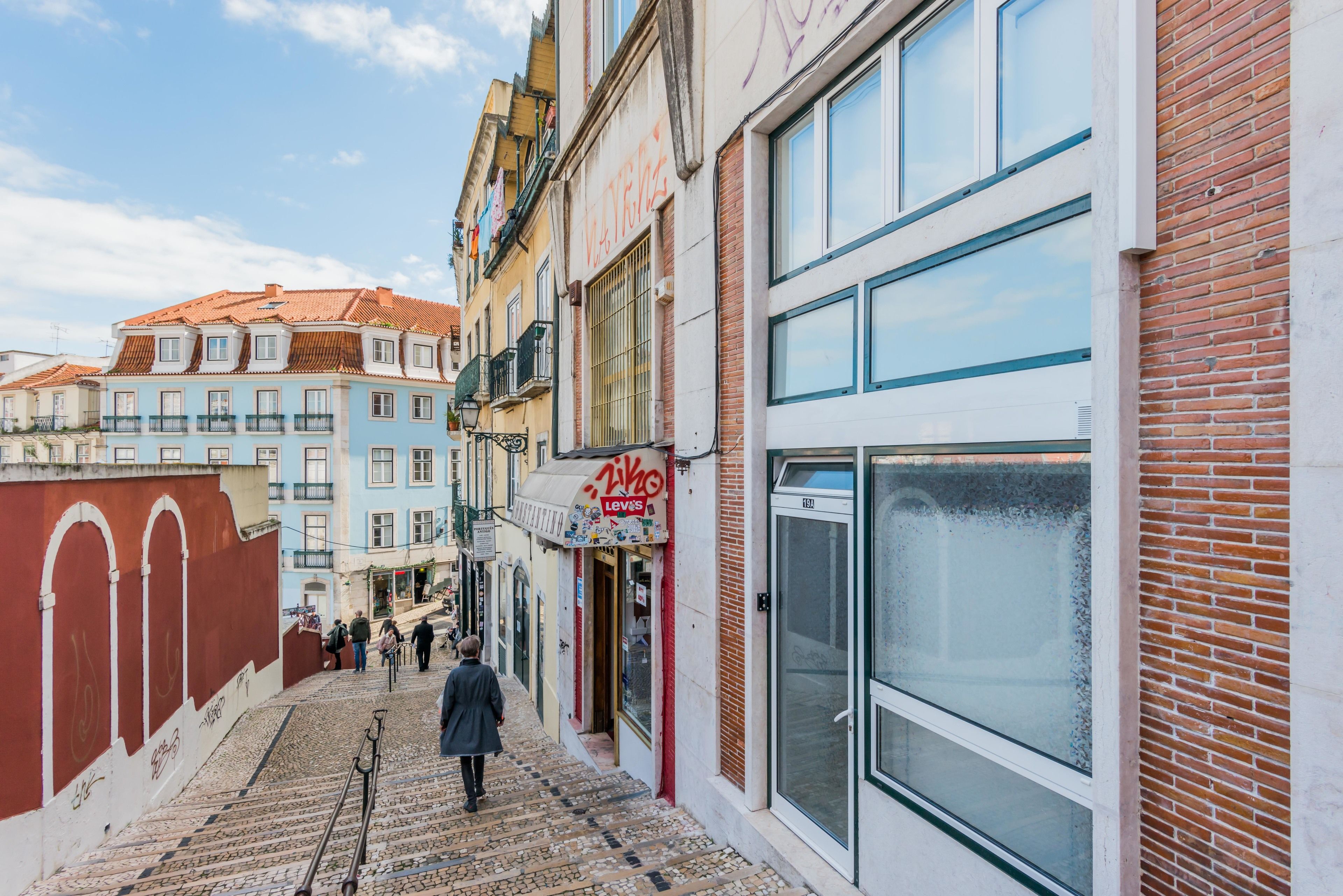 Una calle estrecha flanqueada por edificios, incluyendo una tienda con el letrero 