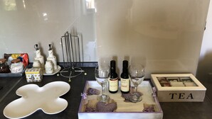 A kitchen counter with a tray holding wine bottles, glasses, and a tea box. - Beautiful wooden house nearby pines forest (Žabljak)