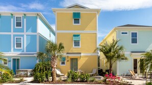 A row of three-story houses with a central yellow building flanked by blue and light blue houses. - Amazing Margaritaville Holiday Home - Indoor/Outdoor Entertaining Space (Kissimmee)